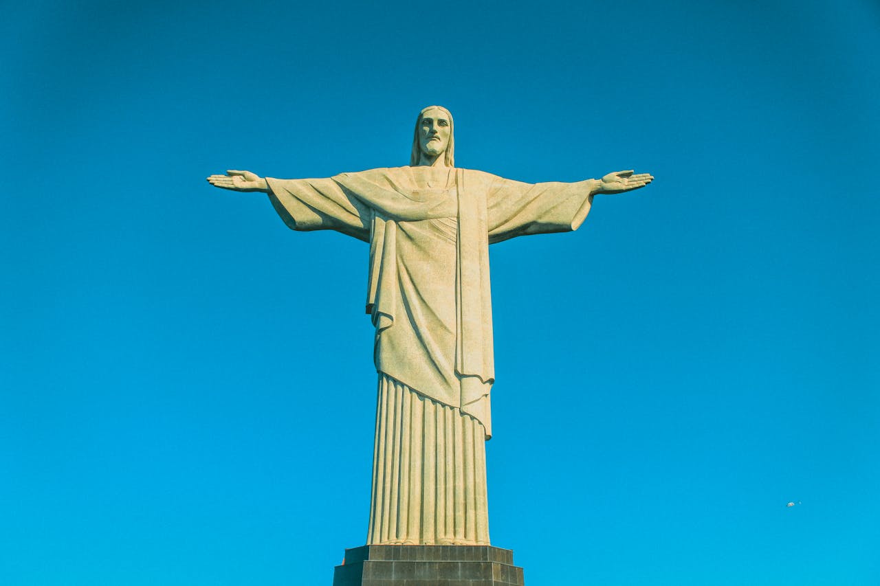 gallery-1 Iconic Christ the Redeemer statue set against a clear blue sky in Rio de Janeiro, Brazil.